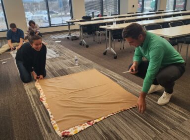 Employees constructing charity blankets for volunteer event