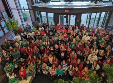 Employees posing for Ugly Christmas Sweater Contest